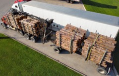 Logging Truck: Heavy truck with a long bunk trailer for hauling felled tree trunks