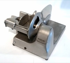 Industrial Meat Slicer: High-speed machine that slices and stacks deli meats